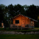 Luxe safaritent aan het water bij Holiday Park Sallandshoeve in Nederland, sfeervol verlicht ’s avonds.