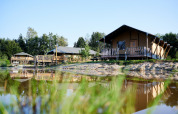 Luxe safaritenten aan het water bij Holiday Park Sallandshoeve in Nederland, omgeven door natuur.