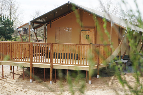 Tente safari de luxe au bord de l’eau au Holiday Park Sallandshoeve, Pays-Bas, avec terrasse en bois.