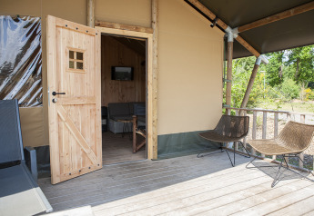 Vista sulla veranda e ingresso di una tenda safari di lusso al Holiday Park Sallandshoeve nei Paesi Bassi.