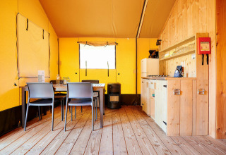 Intérieur d'une tente safari de luxe au bord de l'eau à Holiday Park Sallandshoeve, cuisine et salle à manger.