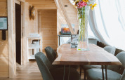 Vista interna di Big Oak Tent presso Holiday Park Sallandshoeve nei Paesi Bassi, con arredi in legno e fiori.