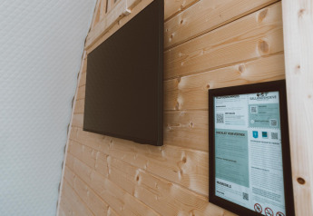 Binnenwand van Big Oak Tent bij Holiday Park Sallandshoeve, Nederland, met tv en informatiescherm.