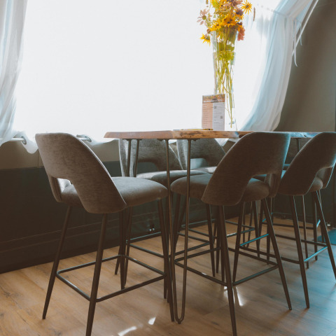 Modern bar stools and table inside Big Oak Tent at Holiday Park Sallandshoeve, Netherlands, with sunlit window.