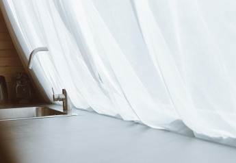 Moderne Spüle mit Wasserhahn und weißen Vorhängen im Big Oak Tent, Holiday Park Sallandshoeve, Niederlande.