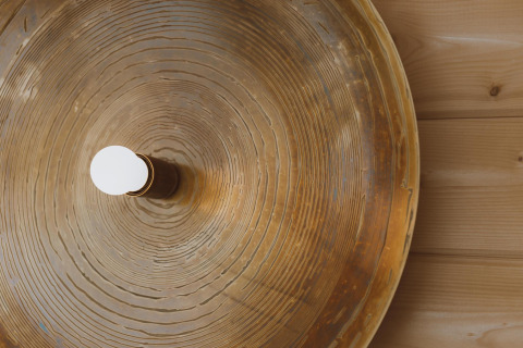 Lampe ronde à motif bois fixée sur un mur en bois, vue du dessus au Big Oak Tent, Holiday Park Sallandshoeve.