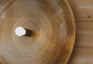Lampe ronde à motif bois fixée sur un mur en bois, vue du dessus au Big Oak Tent, Holiday Park Sallandshoeve.