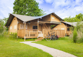 Tenda safari Ranger Lodge presso Holiday Park Sallandshoeve nei Paesi Bassi, veranda in legno e biciclette.
