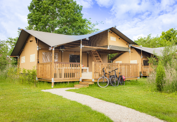 Tente safari Ranger Lodge au Holiday Park Sallandshoeve, Pays-Bas, avec terrasse en bois et vélos garés.