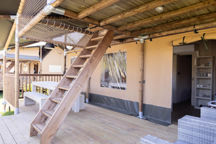 Terrasse en bois, escalier, table et tente safari à la Ranger Lodge du Holiday Park Sallandshoeve.