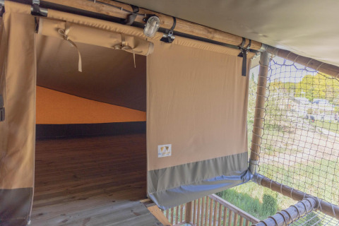 Ingang van de Ranger Lodge safaritent met houten terras bij Holiday Park Sallandshoeve, Nederland.