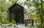 Casa diminuta moderna en Camping Si-Es-An, Países Bajos, rodeada de árboles y con terraza exterior.