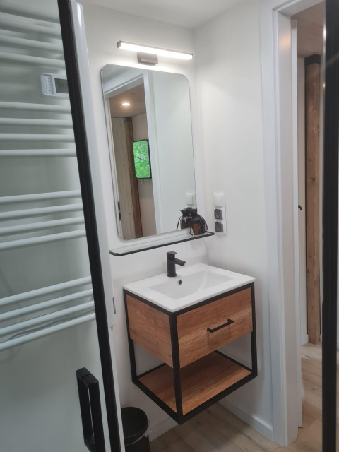Modernes Badezimmer im Tiny house l, Camping Si-Es-An, Niederlande, mit Spiegel und Holzmöbeln.