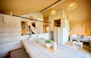 Interior of a Safari tent at Camping Si-Es-An in the Netherlands, featuring wood décor and cozy seating.