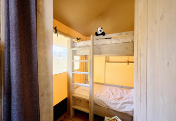 Interieur van een safaritent bij Camping Si-Es-An in Nederland met houten stapelbedden en knuffelpanda.