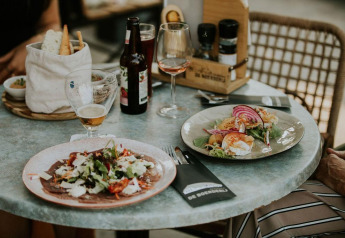 Comida en tienda Safari, Camping Si-Es-An, Países Bajos, con vino, cerveza, pan y ensalada fresca en la mesa.