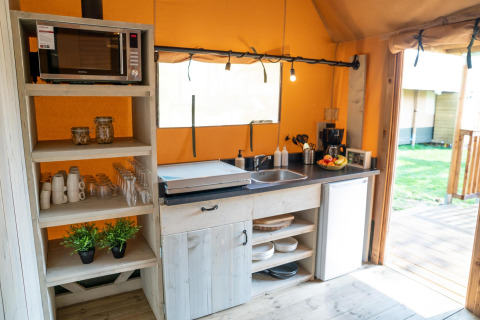 Moderne tekøkken på Ranger lodge ved Camping Si-Es-An i Holland, med mikrobølgeovn, service og frugt.