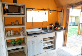 Cocineta de la Ranger lodge en Camping Si-Es-An, Países Bajos, con microondas y nevera pequeña.