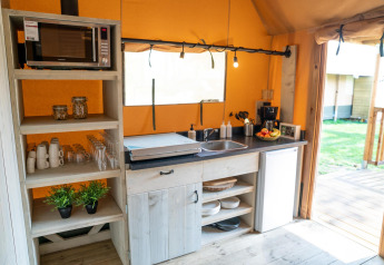 Moderne tekøkken på Ranger lodge ved Camping Si-Es-An i Holland, med mikrobølgeovn, service og frugt.