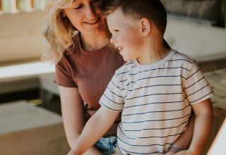 Eine Frau und ein Junge genießen gemeinsam Zeit in der Ranger Lodge auf Camping Si-Es-An, Niederlande.