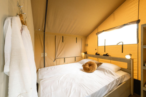 Acogedor dormitorio en la Ranger lodge de Camping Si-Es-An, Países Bajos, con cama doble y luz natural.
