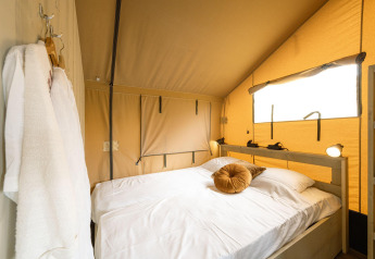 Et komfortabelt soverum i Ranger lodge på Camping Si-Es-An, Nederlandene, med dobbeltseng og naturligt lys.