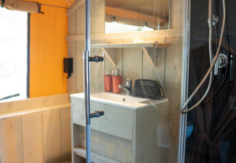 Bagno moderno con doccia, lavandino e specchio nella Ranger Lodge al Camping Si-Es-An nei Paesi Bassi.