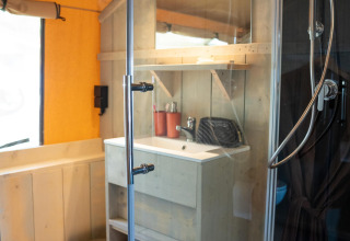 Baño moderno con ducha, lavabo y espejo en la Ranger Lodge de Camping Si-Es-An, Países Bajos.