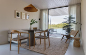 Moderne glamping accommodatie met minimalistisch interieur, uitzicht op het meer en toegang tot het terras.