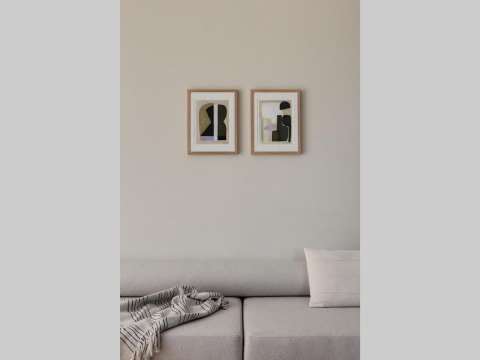 Modern living area with beige sofa, abstract wall art, and cozy blanket at a glamping accommodation.