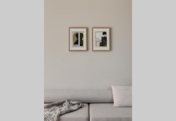 Soggiorno moderno con divano beige, arte astratta alle pareti e coperta accogliente in un glamping.