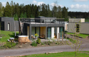 Trævilla med tagterrasse og udendørs vildmarksbad på Resort de Parel i Holland, omgivet af natur.