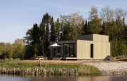 Villa moderna junto al lago en Resort de Parel, Países Bajos, rodeada de árboles y naturaleza.