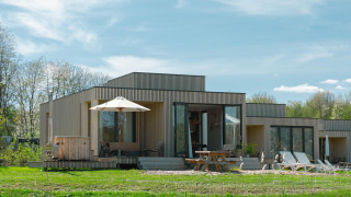 Moderne Villa Hottub-Lodge im Resort de Parel, Niederlande, mit Holzverkleidung und großer Terrasse.