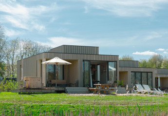 Moderne Villa Hottub-lodge ved Resort de Parel i Holland, med træfacade, terrasse og solsenge.