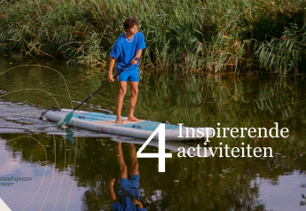 Persona haciendo paddle surf cerca de Villa Hottub en Resort de Parel, Países Bajos, rodeado de naturaleza.