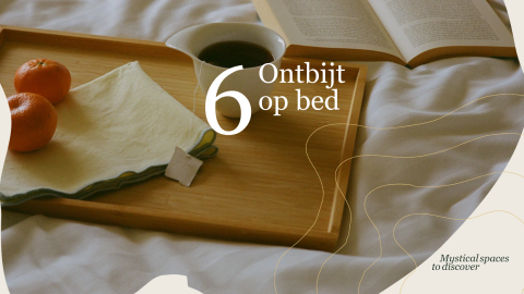 Morgenmad på sengen med te, mandariner og en åben bog på en bakke på Villa Hottub, Resort de Parel.