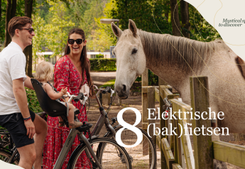 Una familia en bicicleta se detiene en una cerca para conocer un caballo en Villa Hottub, Resort de Parel, Países Bajos.