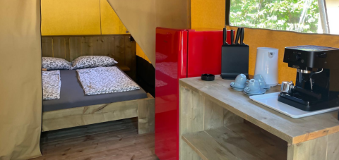Base Lodge safari tent at Camping Gajole in Italy featuring a double bed, kitchenette, and red fridge.