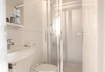 Modern compact badkamer met douche, toilet en wastafel op een woonboot bij Marina Parcs Amsterdam.