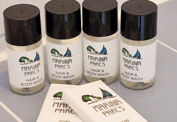 Four bottles of Marina Parcs hair and body wash with two bar soaps arranged on a houseboat bathroom counter.