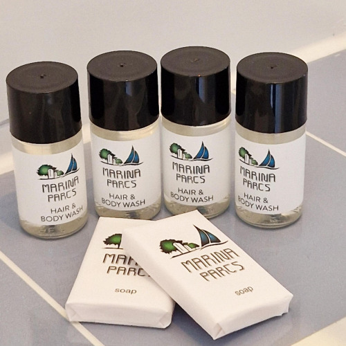 Artículos de tocador en un baño de casa flotante: cuatro botes Marina Parcs Hair & Body Wash y dos jabones.