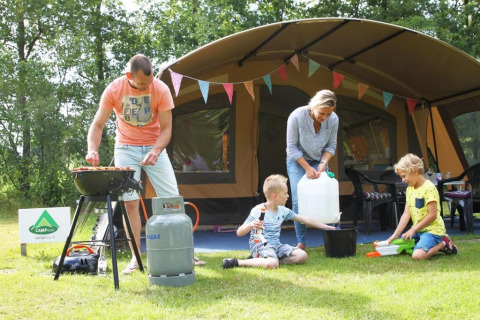 Famille en camping dans une tente safari à CharmeCamping De Regge-Vallei, Pays-Bas, cuisine et jeux dehors.