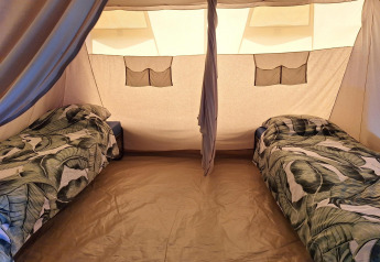 Indersiden af et safaritelt på CharmeCamping De Regge-Vallei i Holland med to enkeltsenge.