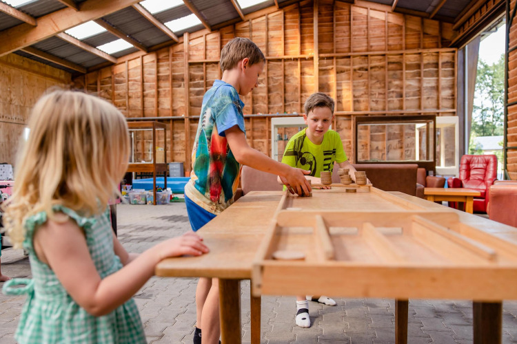 Children play a board game inside a large safari tent at CharmeCamping De Regge-Vallei in the Netherlands.