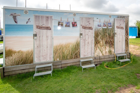 Udendørs badeværelsesfaciliteter ved Tiny Wagon, Marina Parcs Almere, med strandtema i Holland.