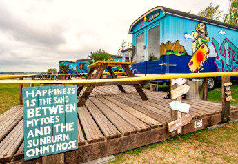 Farverig tiny house ved Marina Parcs Almere, Holland, dekoreret med streetart og hyggeligt udendørsområde.