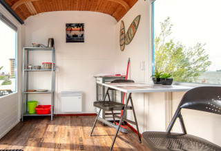Interieur van de Tiny Wagon bij Marina Parcs Almere in Nederland met uitzicht en gezellige eethoek.