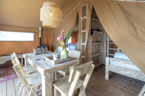 Binnenzicht van een sfeervolle safaritent, Safari lodge, met houten meubilair bij Marina Parcs Almere, Nederland.