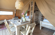 Indvendig udsigt over en hyggelig safaritelt, Safari lodge, med træmøbler ved Marina Parcs Almere, Holland.